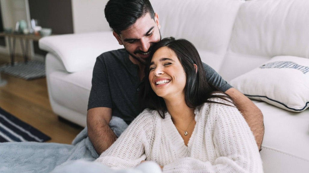 Couples happy with each other sitting near sofa