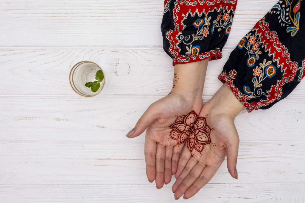 woman applying mehendi on her hands