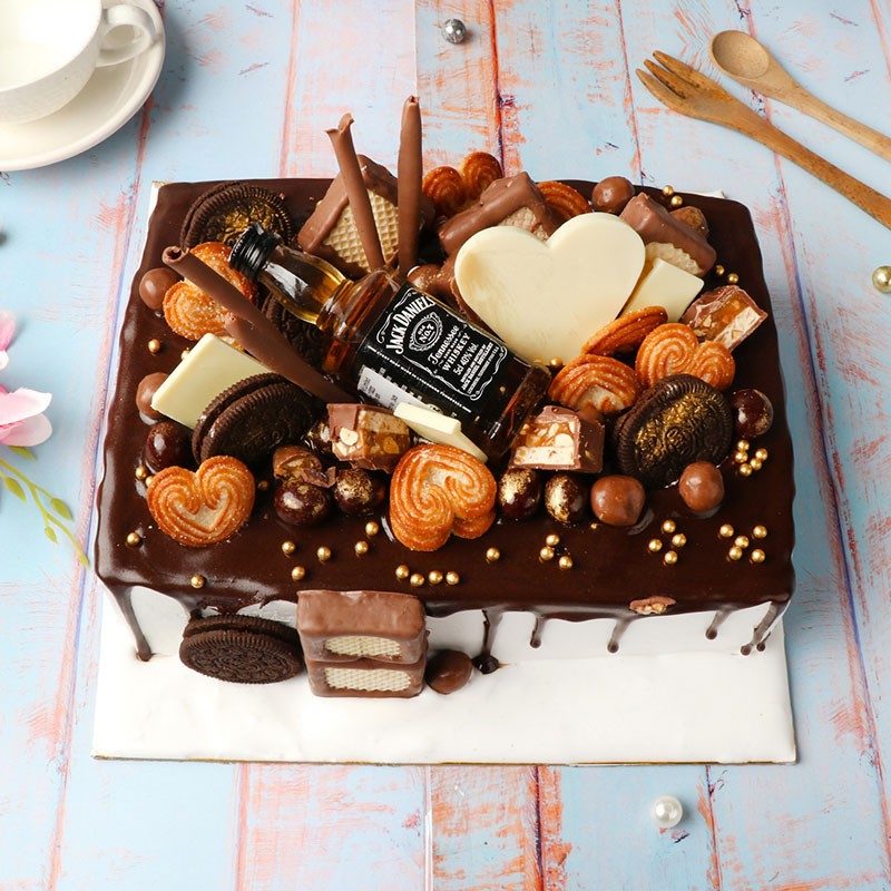 One Kg Chocolate Cream Cake Topped with Oreo Biscuits,Heart Cookies,Snicker Chocolate,Brookside chocolate,milky bar chocolate,strawberry cream wafers and Jack Daniel Miniature Bottle