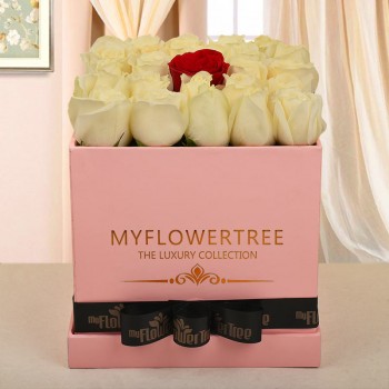 29 white roses and 1 red rose in middle in pink box