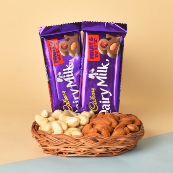 A Cane Basket containing Almonds (100 gms) and Cashew Nuts (100 gms) and 2 Cadbury Dairy Milk Fruit N Nut Chocolates