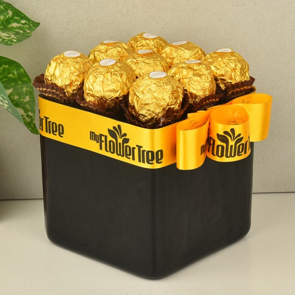 Arrangement of 9 ferrero rochers in a black glass vase