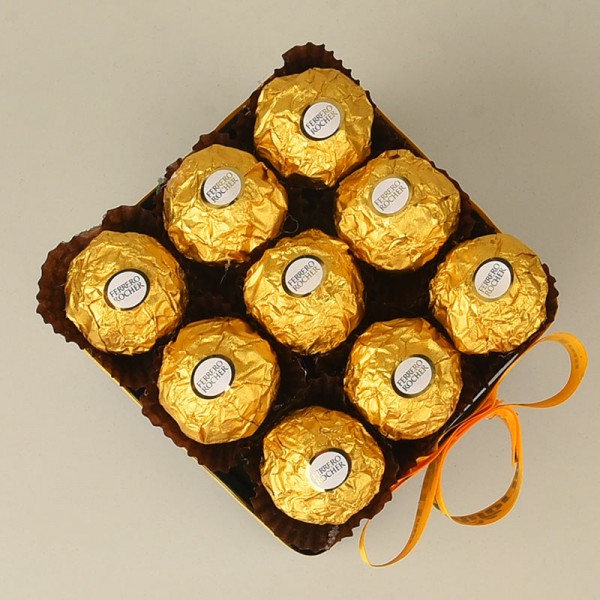 Arrangement of 9 ferrero rochers in a black glass vase