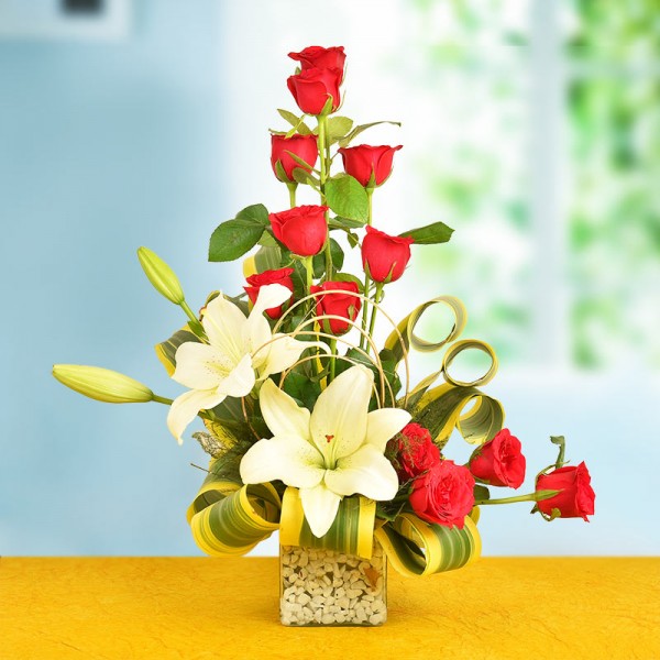 A Floral Arrangement of 12 Red Roses and 2 White Asiatic Lilies in a glass vase