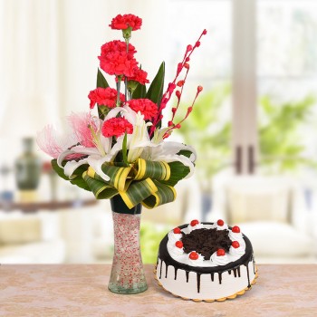  Floral Arrangement of 8 Red Carnations, 2 White Asiatic Lilies with dracaena leaves in a Glass Vase with Half Kg Black Forest Cake