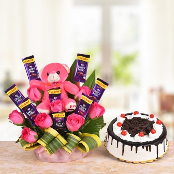  A Basket Arrangement of 8 Pink roses, 8 Cadbury's Dairy Milk of 13 gms each and a Pink Teddy bear (6 Inches) with dracaena leaves and 1/2 Kg Black Forest Cake