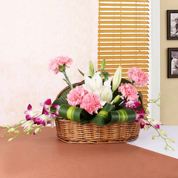 2 White Asiatic Lilies, 5 Pink Carnations, 4 Purple Orchids in Handle Basket