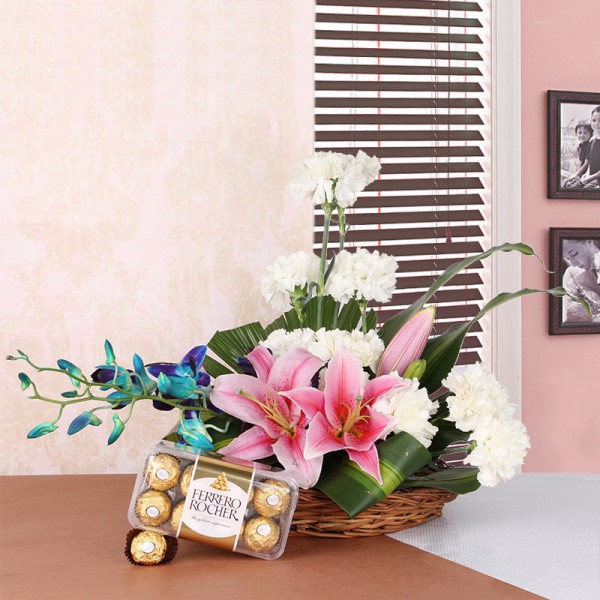 Floral Arrangement like this one. It includes 2 Pink Asaitic Lilies, 10 White Carnations and 2 stems of Blue Orchid in a Basket with a box of 16 pcs of Ferrero Rocher Chocolates