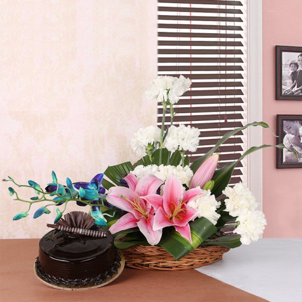 Floral Arrangement like this one. It includes 2 Pink Asiatic Lilies, 10 White Carnations and 2 stems of Blue Orchid in a Basket with Chocolate Truffle Cake (Half Kg)