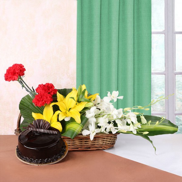 Floral arrangement of 3 Yellow Asiatic Lilies, 4 Red Carnations, 4 White Orchids in Handle Basket with Chocolate Truffle Cake (Half Kg)