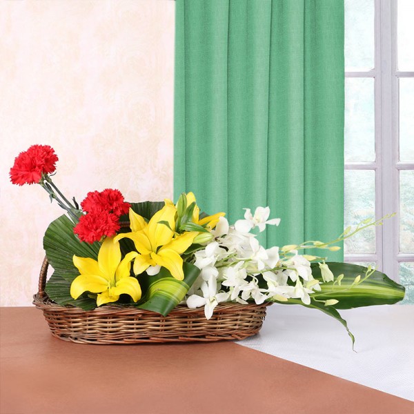 3 Yellow Asiatic Lilies, 4 Red Carnations, 4 White Orchids in Handle Basket