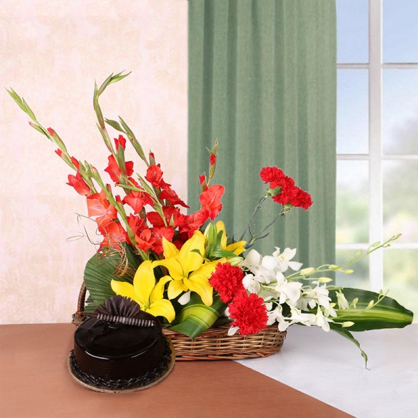 Floral Arrangement of 3 Yellow Asiatic Lilies, 4 Red Glads, 4 Red Carnations and 2 White Orchids in a Basket with Chocolate Truffle Cake (Half Kg)