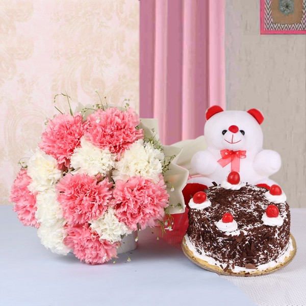 12 Carnations (Pink and White) in White Paper packing with Black Forest Cake (Half Kg) and Teddy Bear (6 inches)