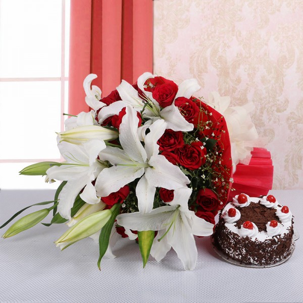 4 White Asiatic Lilies and 15 Red Roses in Red paper, White paper bow with Back Forest Cake (Half Kg)