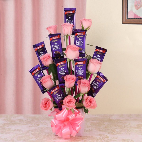 Arrangement of 12 Pink Roses and 10 Dairy Milk Chocolates (13gms each) in Glass Vase