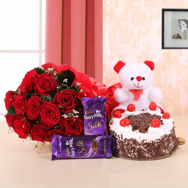 10 Red Roses in Paper Packing with 2 Cadbury's Dairy Milk Silks and Black Forest Cake (Half Kg) and 1 Teddy Bear (6 Inches)