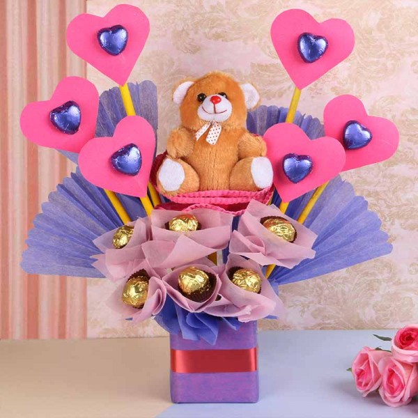 An arrangement of 1 Teddy Bear( 6 inches), 6 round-shaped assorted chocolates, 6 heart-shaped assorted chocolates in a vase