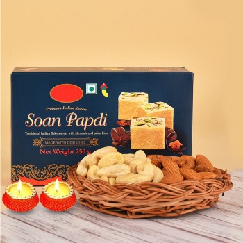 A Pack of Soan Papdi (250 gms) with a Cane Basket containing Almonds (100 gms) and Cashew Nuts (100 gms) with Set of 2 Diya for Diwali