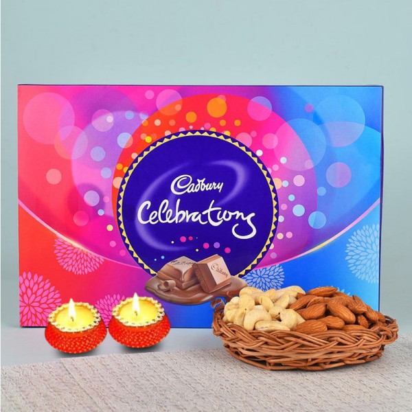 A Cane Basket containing Almonds (100 gms) and Cashew Nuts (100 gms) with 1 Cadbury Celebrations Pack (131.3 gms) and Set of 2 Diya for Diwali