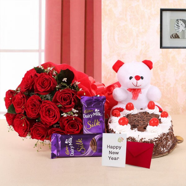 10 Red Roses in Paper Packing with 2 Cadbury's Dairy Milk Silks and Black Forest Cake (Half Kg) and 1 Teddy Bear (6 Inches) along with New Year Greeting Card (6 inches)