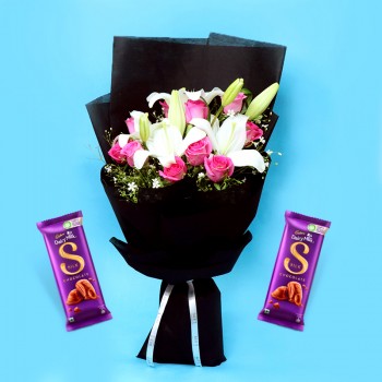 A bunch of Flowers (12 Red Roses, 3 White Asiatic Lily) in Red and White Paper Packing, White Paper Bow with 2 Cadbury's DairyMilk Silk (60gms each)